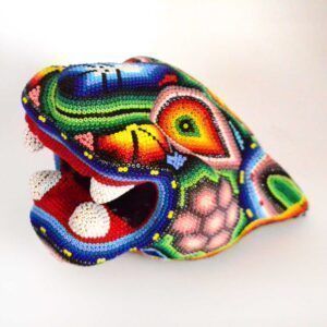 Figura de cabeza de jaguar intervenida con arte huichol